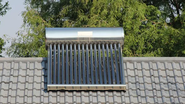 Evacuated tube solar water heater with a stainless-steel storage tank on a tiled roof